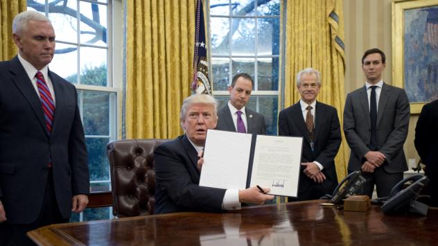 Президентът на САЩ Доналд Тръмп държи на показ изпълнителната си заповед, с която изтегли САЩ от ТТП Снимка: Ron Sachs/Pool via Bloomberg