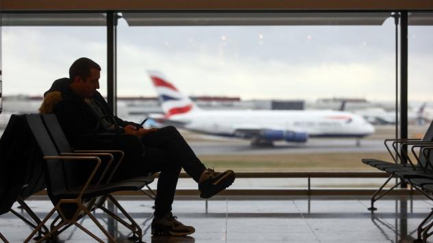 Пътник чака полета си на летище Хийтроу, където в момента каза самолет на British Airways. Лондон. 23 декември 2016. Photographer: Chris Ratcliffe/Bloomberg
