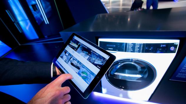 Служител използва iPad Mini 3 на Apple, за да демонстрира приложението за умни перални на Siemens; Photographer: Krisztian Bocsi/Bloomberg