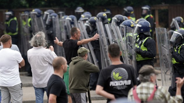 Полицията за борба с безредиците влиза в сблъсък с протестиращи срещу миграцията пред Holiday Inn Express в Манвърс, Великобритания, който се използва като хотел за предоставяне на убежище, на 4 август. Снимка: Bloomberg LP