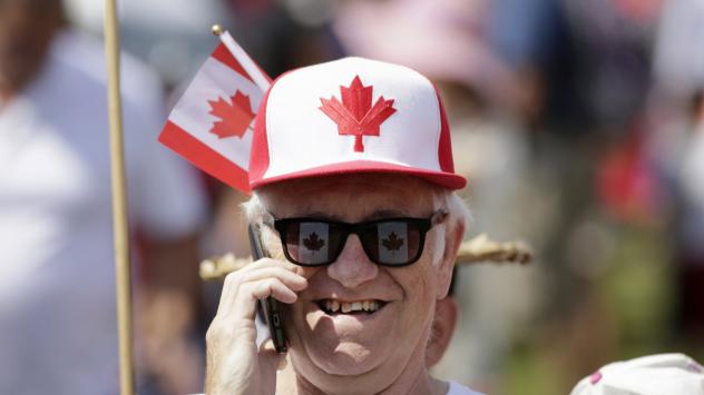 Възрастен гражданин в провинция Албърта говори по телефона, празнувайки Деня на Канада Снимка: David Kawai/Bloomberg