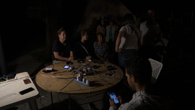 Граждани на Каракас зареждат мобилните си телефони от генератор. Снимка: Carlos Becerra/Bloomberg