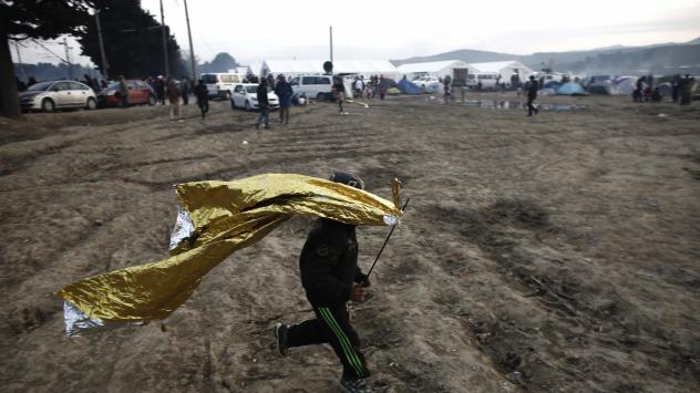 Дете си играе с термално одеяло в лагер край гръко-македонската граница Снимка: Kostas Tsironis/Bloomberg