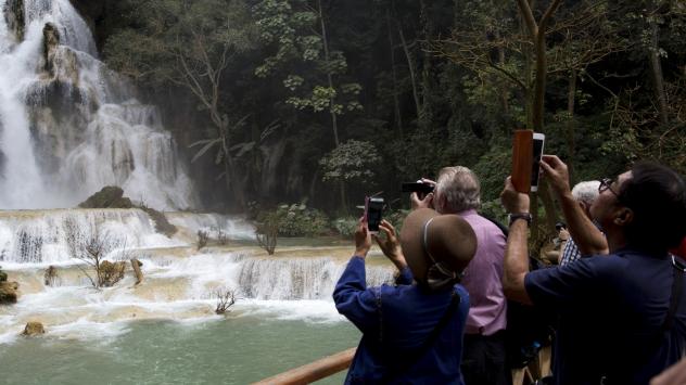 Туристи снимат водопад по време на разходка Снимка: Brent Lewin/Bloomberg