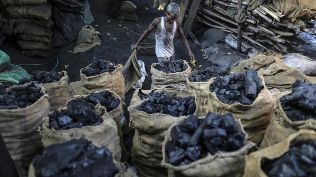 Работник носи торби с въглища на борсата в Мумбай, Индия. 12 май 2016. Photographer: Dhiraj Singh/Bloomberg 
