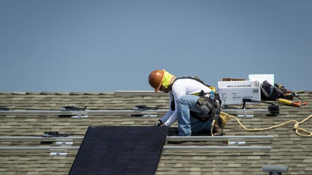 Работник монтира слънчев панел на къща в Сакраменто. Снимка: David Paul Morris/Bloomberg