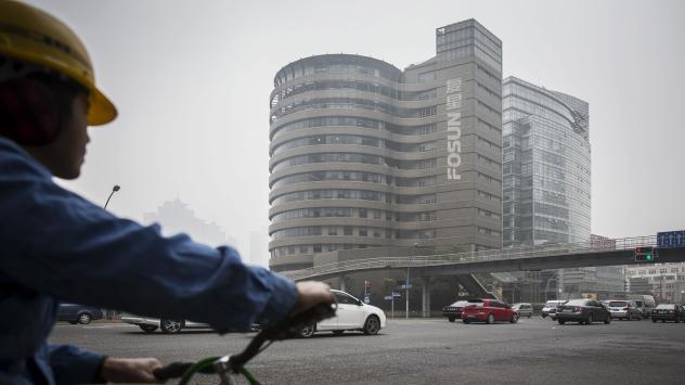 Велосипедист минава край сградата на Fosun International Ltd. в Шанхай на 11 декември 2015. Photographer: Qilai Shen/Bloomberg