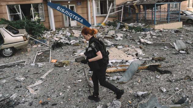 Русия удари Киев с ракетна вълна. Полицай събира части от ракети от дрон от жилищен район след руска нощна атака в Киев на 6 юни. Снимка: Bloomberg LP