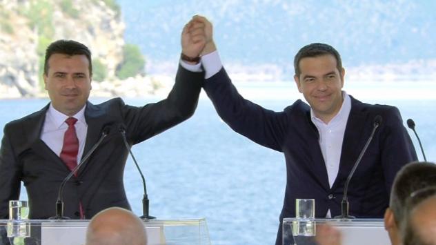 Премиерът на Македония Зоран Заев, в ляво и премиерът на Гърция Алексис Ципрас, в дясно след подписване на споразумението за името на Македония. 17 юни 2018. Преспанското езеро. Снимка: скрийншот BulgariaONAIR
