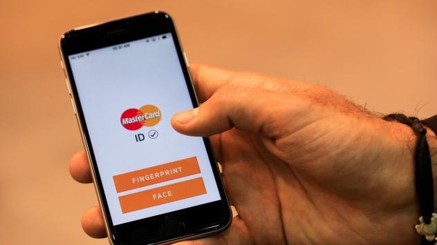 Служител на MasterCard Inc. демонстрира приложение със защита с пръстов отпечатък и лицеворазпознаване на Mobile World Congress. 24/2/2016. Барселона. Photographer: Pau Barrena/Bloomberg