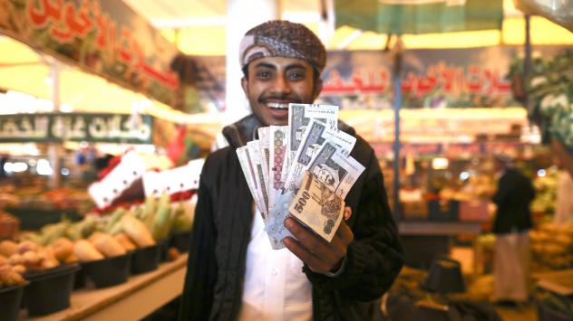 Търговец държи банкноти от 500 саудитски риала на пазар в столицата Рияд; Photographer: Simon Dawson/Bloomberg