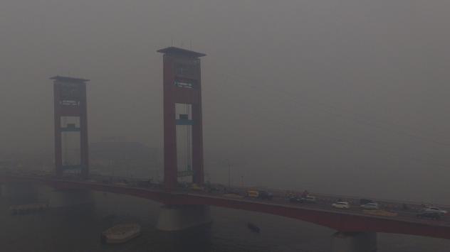 Мостът Ампера на о-в Суматра, Индонезия. Високо замърсяване на въздуха от запалените торфища. Photographer: Dimas Ardian/Bloomberg