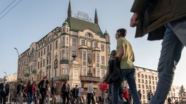 Седнала зад огромно черно дървено бюро и подредени в купчини