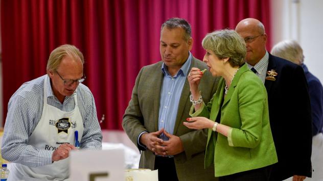 Британският премиер Тереза Мей опитва местно сирене на Royal Bath and West Show по време на предизборната си обиколка в Шептън Мале, Великобритания. 31 май 2017. Photographer: Facundo Arrizabalaga/Pool via Bloomberg
