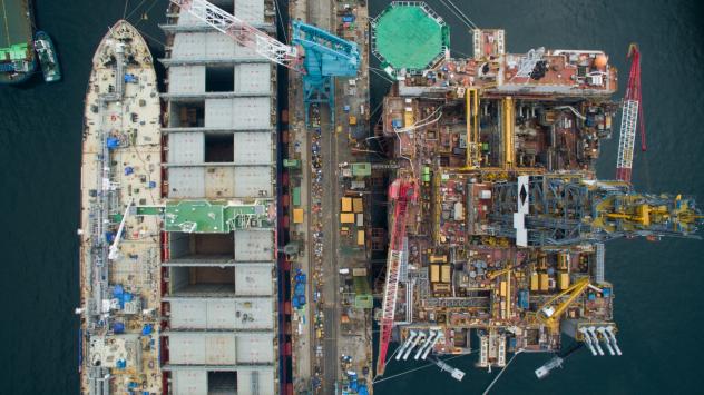 Танкери за ВПГ (ляво) и недовършена платформа за газ (дясно) на Hyundai Heavy Industries Co.; Photographer: SeongJoon Cho/Bloomberg