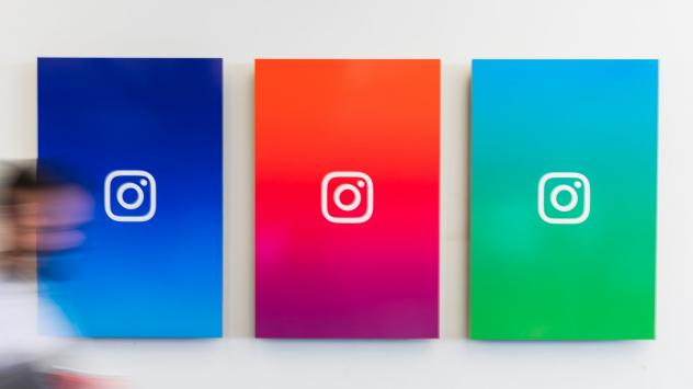 Служител минава пред брандирани постерени на Instagram в Ню Йорк Снимка: Jeenah Moon/Bloomberg