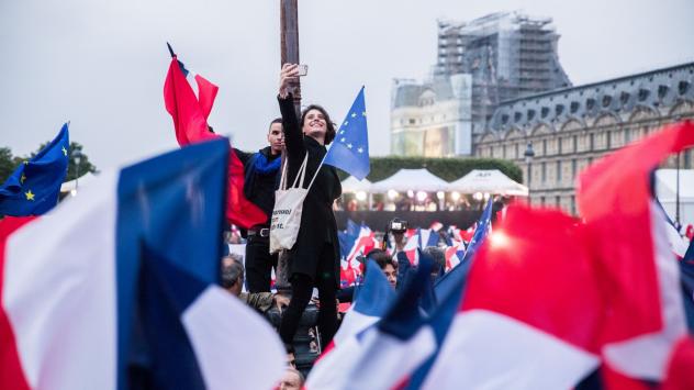 Привърженичка на президента на Франция Еманюел Макрон си прави селфи пред Лувъра след обявяване на резултатите от балотажа на президентските избори на 7 май 2017. Photographer: Christophe Morin/Bloomberg 