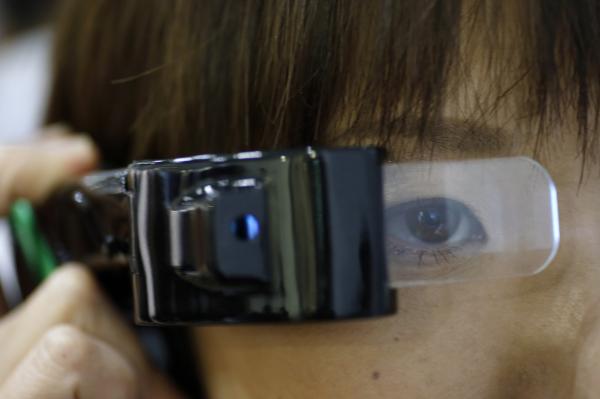 <p>Гост на изложението за технология, която може да се носи по тялото изпробва проектор на Sharp Corp. - LCOS на изложението в Токио Wearable Expo на 13 януари 2016. Photographer: Tomohiro Ohsumi/Bloomberg</p>
