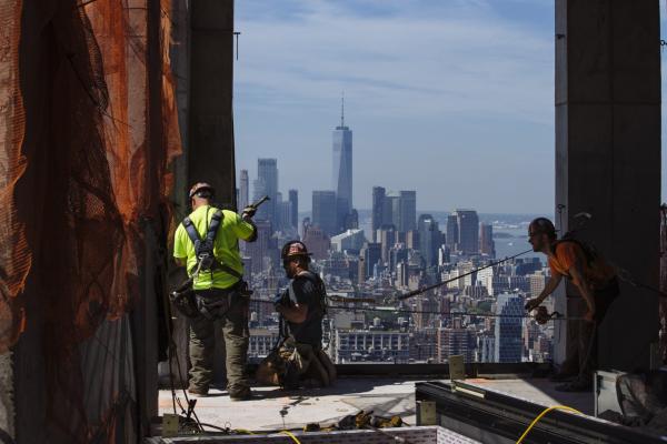 <p>Работници довършват фасадата на новострояща се луксозна жилищна сграда на Пето авеню. Ню Йорк, 29 юни 2018. Photographer: Angus Mordant/Bloomberg.</p>
