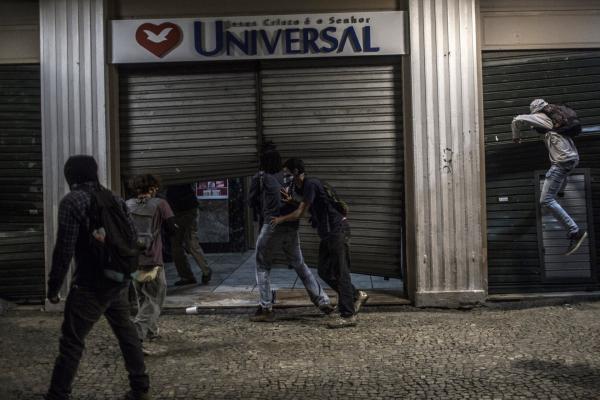 <p>Демонстранти разбиват витрина на улицата в Рио де Жанейро, Бразилия. 18 май 2017. Photographer: Dado Galdieri/Bloomberg.<br />
Дори и преди натиска през уикенда, инвеститорите започнаха да губят ентусиазъм за 76-годишния политик, чийто рейтинг през април падна до едноцифрени стойности, пише Bloomberg. Шансът правителството да одобри до октомври важна пенсионна реформа, нужда за решаване на проблема с изчерпаните публични средства намаля до 5%, каза Ренато Нобиле, директор на Bullmark Financial Group.</p>
