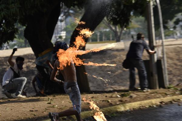 <p>Протестиращ член на опозицията мята коктейл Молотов по членове на Националните боливарски въоръжени сили в Алтамира, Венецуела. 1 май 2019. Photographer: Carlos Becerra/Bloomberg.</p>

<p>Провалът на бунта срещу президента Николас Мадуро във Венецуела може да доведе до по-строги американски санкции, които още повече ще свият износа от богатата на петрол страна.</p>
