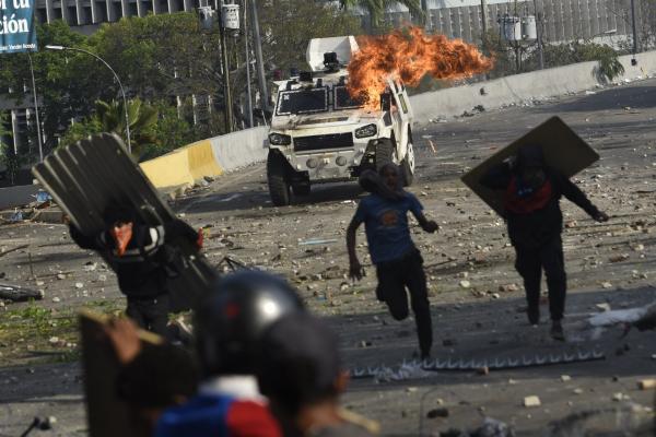 <p>Запалена бронирана кола при сблъсъци между членове на Националните боливарски въоръжени сили и опозицията на магистрала Франциско Фахардо в Алтамира, Венецуела. 1 май 2019. Photographer: Carlos Becerra/Bloomberg.</p>
